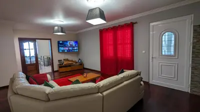 a living room with a couch and red curtains at Levada Nova House in Ponta do Sol