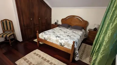 a bedroom with a bed and a chair at Levada Nova House in Ponta do Sol