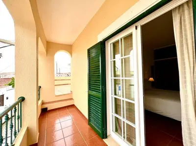 a balcony with a green door and a window at Casa Rosado típica portuguesa in Barão de São João