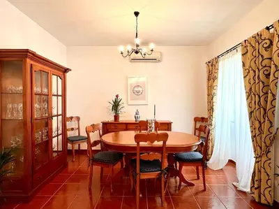a dining room with a wooden table and chairs at Casa Rosado típica portuguesa in Barão de São João