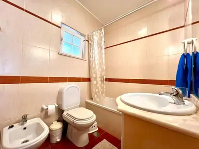 a bathroom with a toilet and a sink at Casa Rosado típica portuguesa in Barão de São João