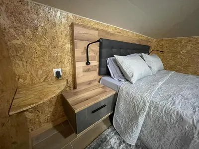 a bedroom with a bed and a wooden wall at Dream Home in Calheta