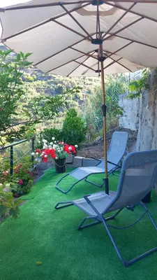 two chairs and an umbrella on a lawn at Dream Home in Calheta