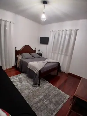 a bedroom with a bed with white curtains and a rug at Dream Home in Calheta