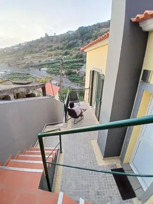 a balcony of a house with a table and a chair at Dream Home in Calheta