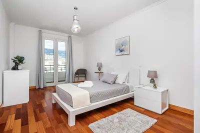 a white bedroom with a bed with two towels on it at Sun Hills Panoramic Views in Funchal