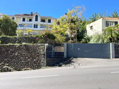 a stone wall next to a street with houses at Sun Hills Panoramic Views in Funchal