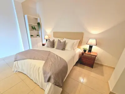 a bedroom with a large white bed with two lamps at Sunshine Palace Madeira - Live Your Sunniest Dream! in Ponta do Sol