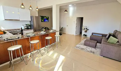 a kitchen and living room with a bar and a couch at Sunshine Palace Madeira - Live Your Sunniest Dream! in Ponta do Sol
