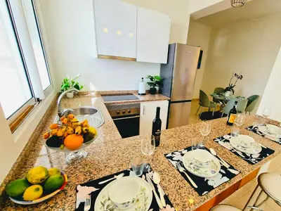 a kitchen with a counter with a bowl of fruit on it at Sunshine Palace Madeira - Live Your Sunniest Dream! in Ponta do Sol