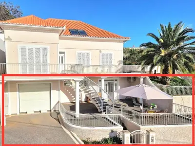 a large white house with stairs and an umbrella at Sunshine Palace Madeira - Live Your Sunniest Dream! in Ponta do Sol