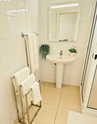 a white bathroom with a sink and a mirror at Sunshine Palace Madeira - Live Your Sunniest Dream! in Ponta do Sol