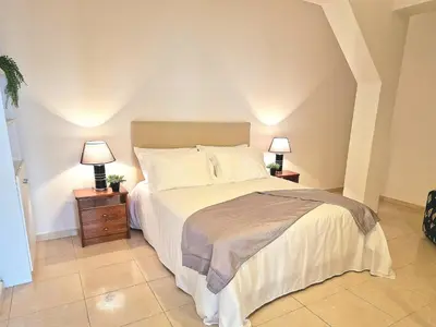 a bedroom with a bed and two lamps on tables at Sunshine Palace Madeira - Live Your Sunniest Dream! in Ponta do Sol