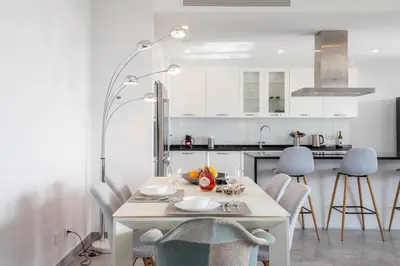 a white kitchen with a white table and chairs at Casa Chloe Luxury Oceanview Penthouse in Lagos