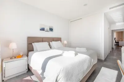 a white bedroom with a large bed with white sheets at Casa Chloe Luxury Oceanview Penthouse in Lagos