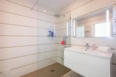 a white bathroom with a sink and a mirror at Casa Chloe Luxury Oceanview Penthouse in Lagos