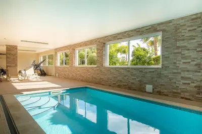 a swimming pool in a house with a brick wall at Casa Chloe Luxury Oceanview Penthouse in Lagos
