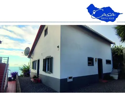 a white building with a blue sign on it at Holiday home Casa Brisa Mar in Prazeres in Prazeres
