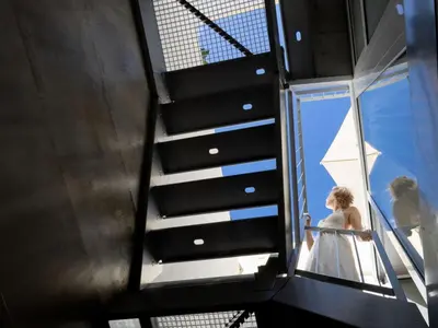 a woman in a white dress standing on a staircase at Fisherhouse23 Comfortable holiday residence in Câmara de Lobos