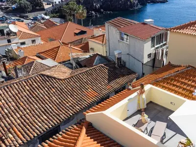an aerial view of roofs of houses and the water at Fisherhouse23 Comfortable holiday residence in Câmara de Lobos