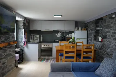 a kitchen and living room with a couch and a table at Casa do Lombo in Machico
