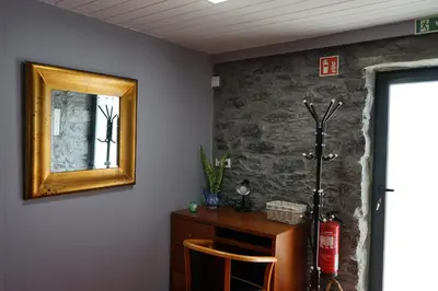 a mirror on a wall next to a wooden table at Casa do Lombo in Machico
