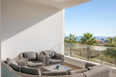 two chairs and a table in a room with a balcony at Casa Lilou - Luxury Oceanview Penthouse in Lagos