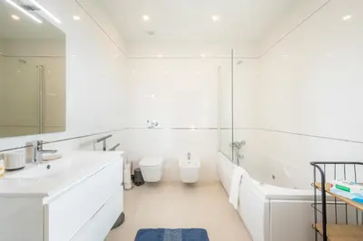 a white bathroom with a tub and a sink at Casa Lilou - Luxury Oceanview Penthouse in Lagos