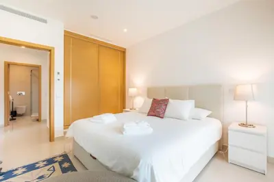 a bedroom with a large white bed and a mirror at Casa Lilou - Luxury Oceanview Penthouse in Lagos