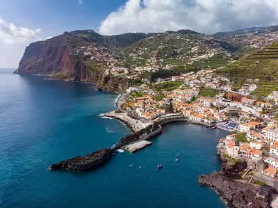 an aerial view of a town on a hill next to the ocean at Madeira property in Câmara de Lobos