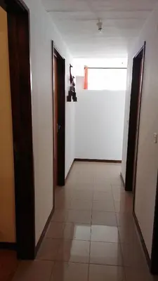 an empty hallway with two doors and a window at Madeira property in Câmara de Lobos