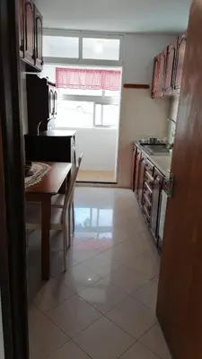 a kitchen with a table and a table and a window at Madeira property in Câmara de Lobos