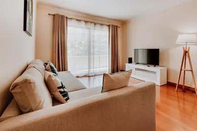 a living room with a couch and a television at Monumental Lidoview in Funchal