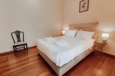 a bedroom with a white bed and a chair at Monumental Lidoview in Funchal