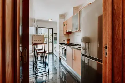 a kitchen with wooden cabinets and a counter top at Monumental Lidoview in Funchal