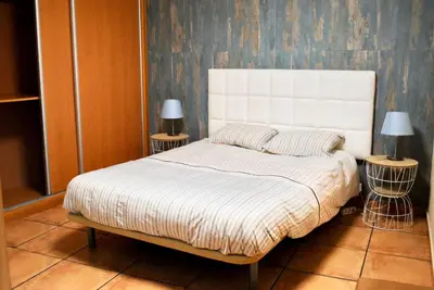 a bedroom with a white bed with two lamps at Casa da Adega in Machico