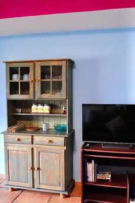 a wooden entertainment center with a tv in a living room at Casa da Adega in Machico