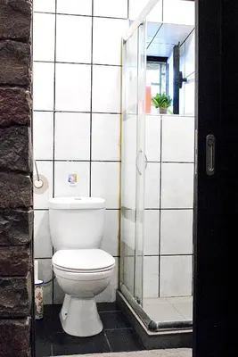 a bathroom with a toilet and a glass shower at Casa da Adega in Machico