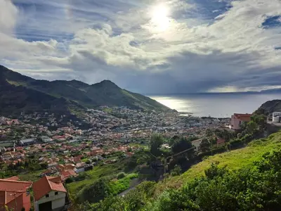 a town on a hill next to the ocean at Casa da Adega in Machico