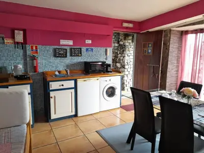 a kitchen with a washer and dryer and a table at Casa da Adega in Machico