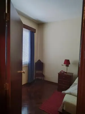 a bedroom with a bed and a chair and a window at casa na Torre in Machico