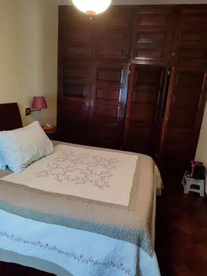 a bedroom with a bed and wooden doors at casa na Torre in Machico