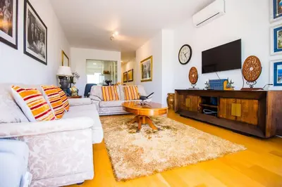 a living room with a white couch and a tv at Santino Apartment in Caniço