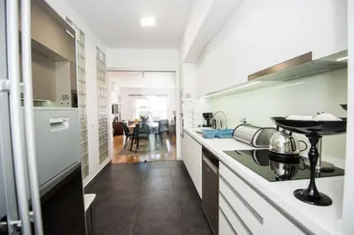 a kitchen with white counters and a stove top oven at Santino Apartment in Caniço