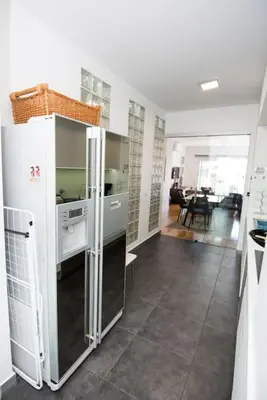 a kitchen with a refrigerator and a dining room at Santino Apartment in Caniço