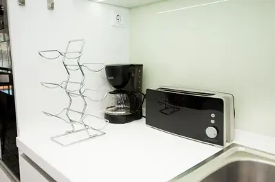 a kitchen counter with a microwave and a coffee maker at Santino Apartment in Caniço