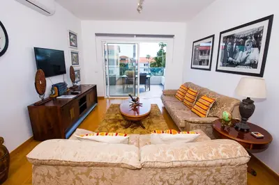 a living room with a couch and a tv at Santino Apartment in Caniço