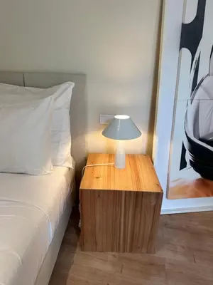 a lamp on a wooden table next to a bed at Downtown collection apartments II in Funchal