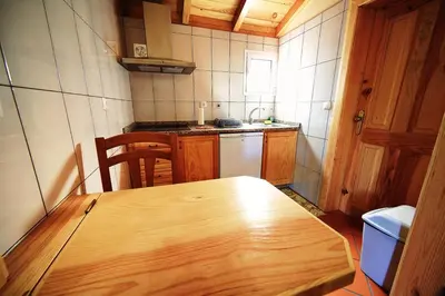 a wooden table in a small kitchen with a sink at Herdade do Pedregal in Ponta do Pargo