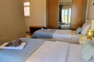 a hotel room with two beds and a mirror at Deluxe 3 bedroom townhouse - Quinta da Atalaia in Lagos